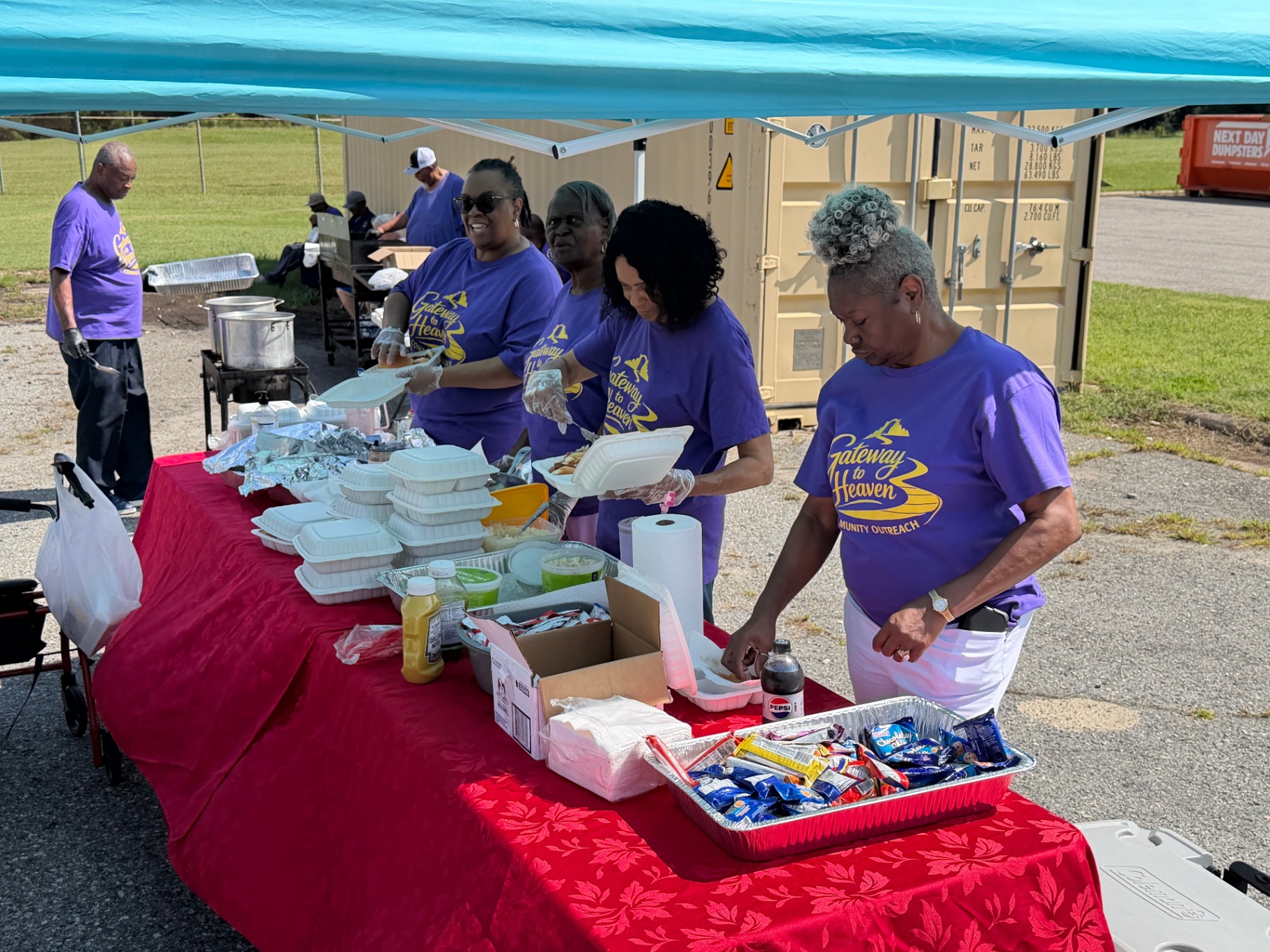 Gateway to Heaven volunteers preparing meals at an outdoor community event