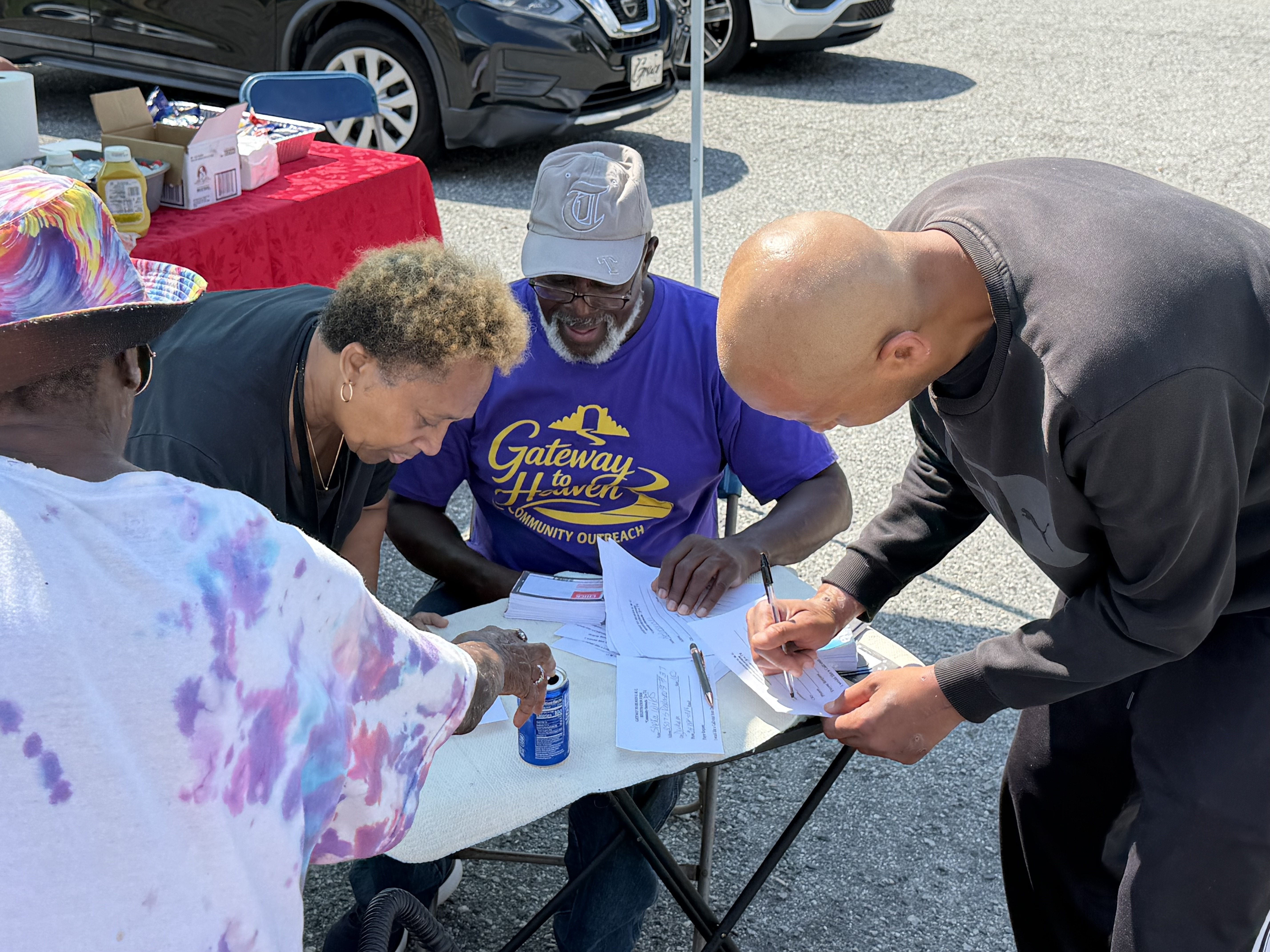 Volunteers welcoming and registering a neighbor at a community event